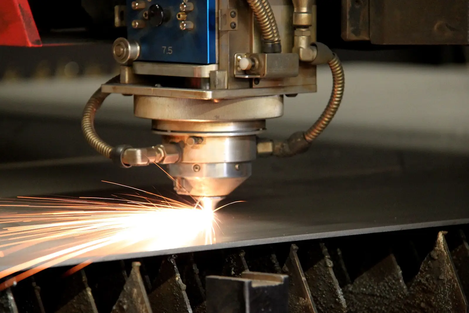 Sac levhayı kesen lazer kesim makinesinin kafası ve kıvılcımlar